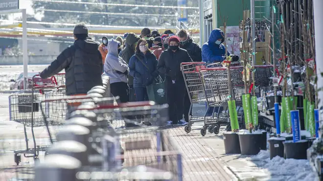 Shoppers queue for food outside a Texas supermarket during the big freeze