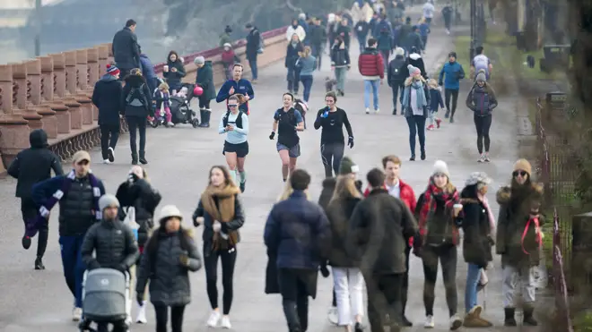People walk and run through Battersea Park, London, during England's third national lockdown
