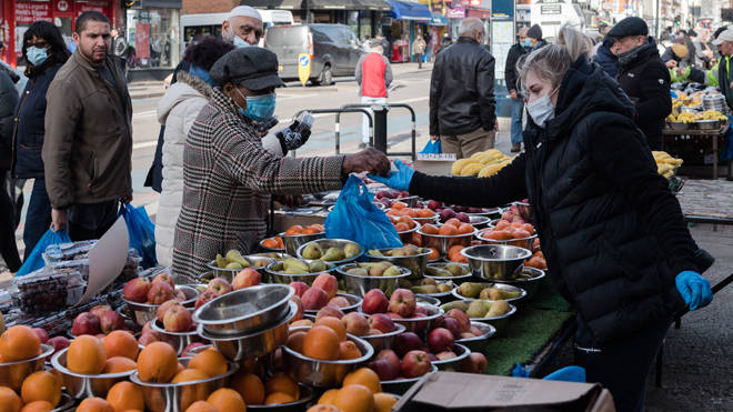 People shop at an outdoor fruit and vegetable market in Tooting in South Londo