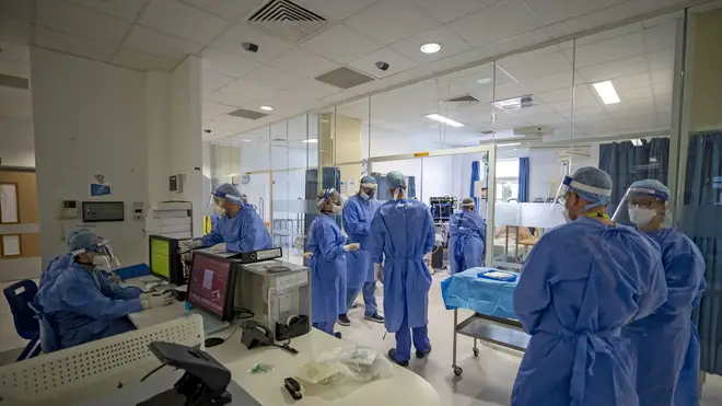 Health workers wearing full personal protective equipment (PPE) on the intensive care unit (ICU) at Whiston Hospital in Merseyside