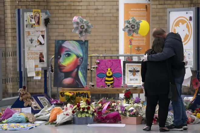 People grieve at a memorial of the Manchester Arena attack