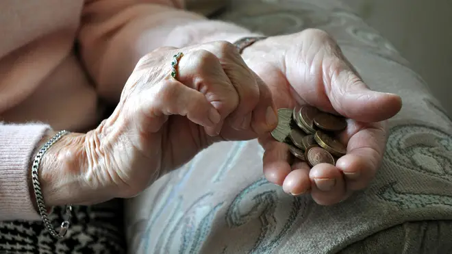 An elderly woman with loose change in her hands