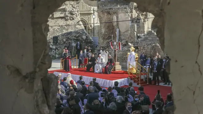 Pope Francis surrounded by shells of destroyed churches
