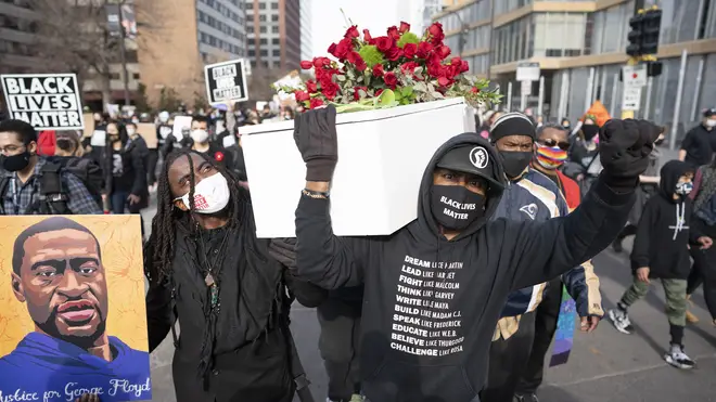 Cortez Rice, left, a friend of George Floyd, and Raj Sethuraju carried a mock coffin to mourn the death of George Floyd during a rally in Minneapolis, Minnesota