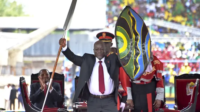 Tanzania’s President John Magufuli holds up a ceremonial spear and shield (Khaifan Said/AP)