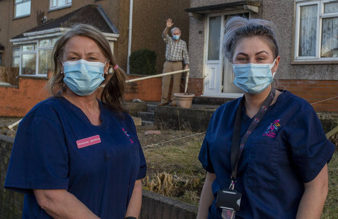 Community Care workers Vivienne Jenkins and Chantelle Healy leave a house after providing social care in Blackwood, Wales.