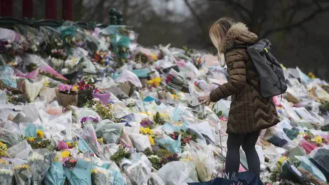 A woman lays flowers at the bandstand in Clapham Common, London, for Sarah Everard