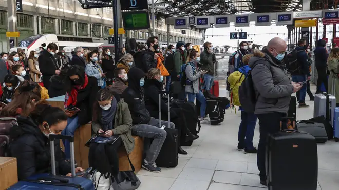 People wait to leave Paris at Gare de Lyon station as the new lockdown came into effect