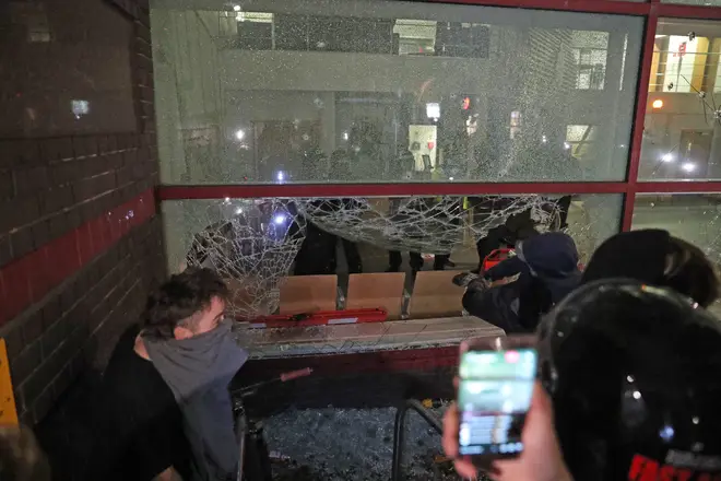 Protester smashes a window with a stick outside Bridewell Police Station