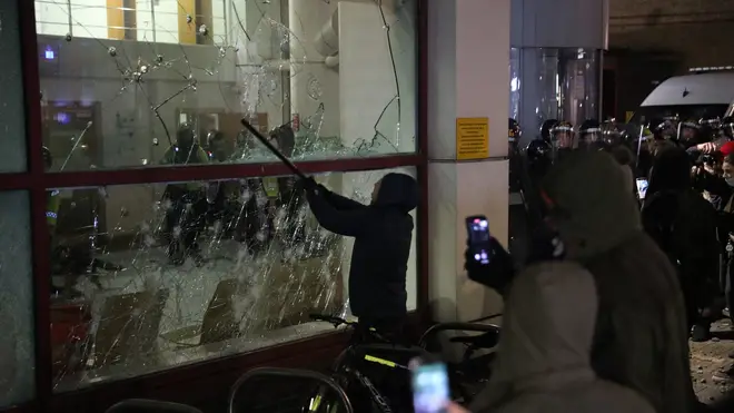 A protester smashes a Bridewell Police Station window