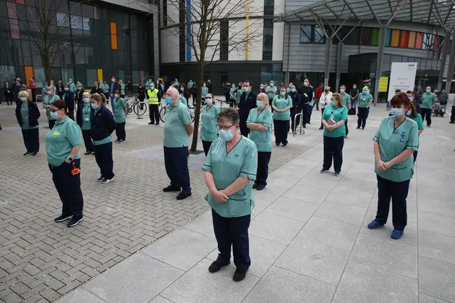 Staff observe a minute's silence outside the Queen Elizabeth University Hospital in Glasgow, during the National Day of Reflection
