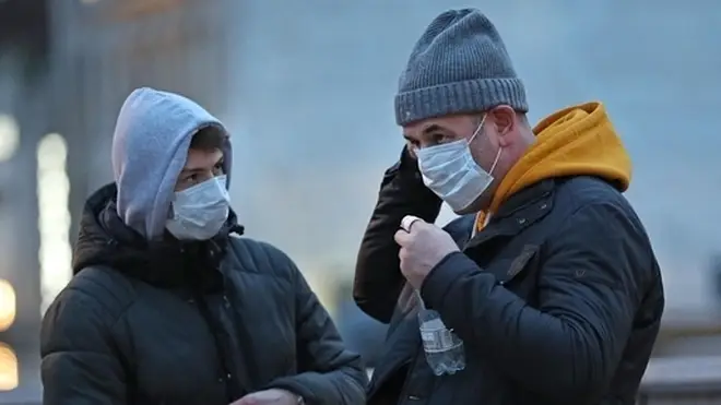 People wearing face masks in Trafalgar Square, London.