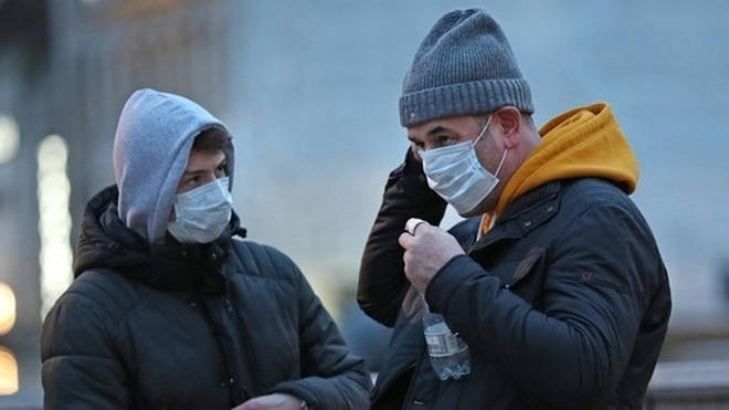People wearing face masks in Trafalgar Square, London.