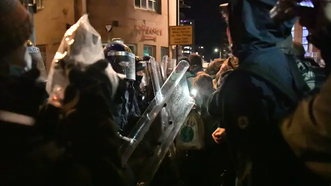 Police with riot shields clash with protesters in Bristol