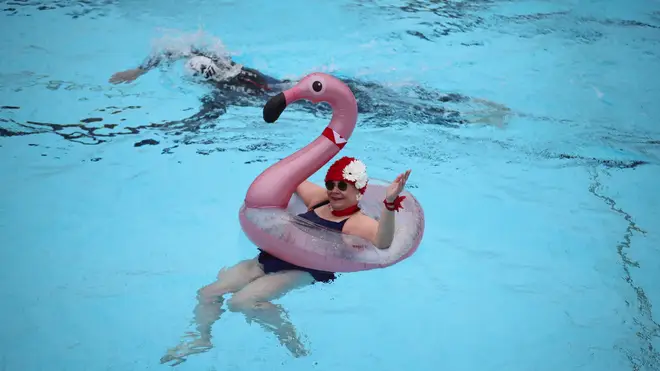 A lido user enjoys a swim with an inflatable flamingo.