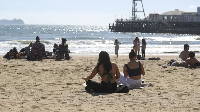 Beach-goers gather in Bournemouth to soak in some sun by the sea.