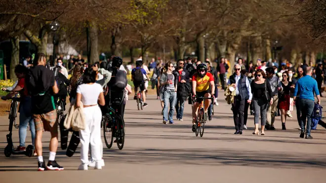 People walk and ride beside in warm spring sunshine beside the Serpentine in Hyde Park as England's lockdown eases