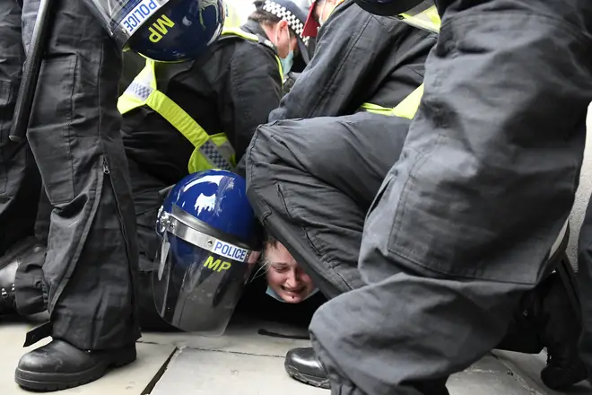 Police restrain a demonstrator during clashes following a 'Kill the Bill' protest.