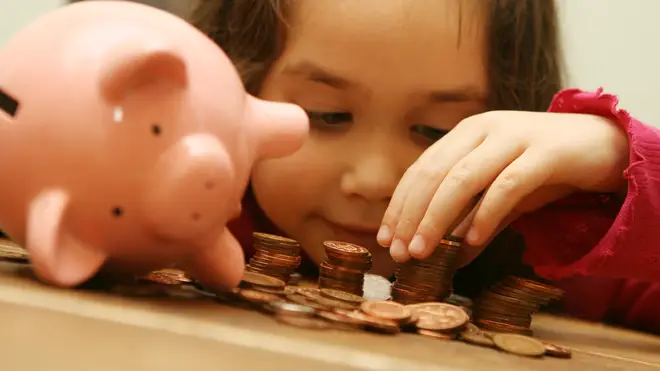 A girl counts the money in her piggy bank