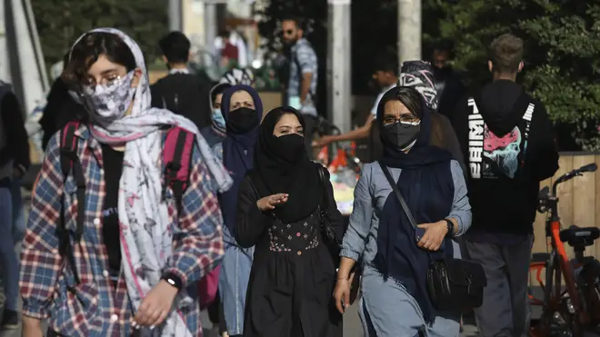 People wear protective face masks to help prevent the spread of coronavirus (Vahid Salemi/AP)