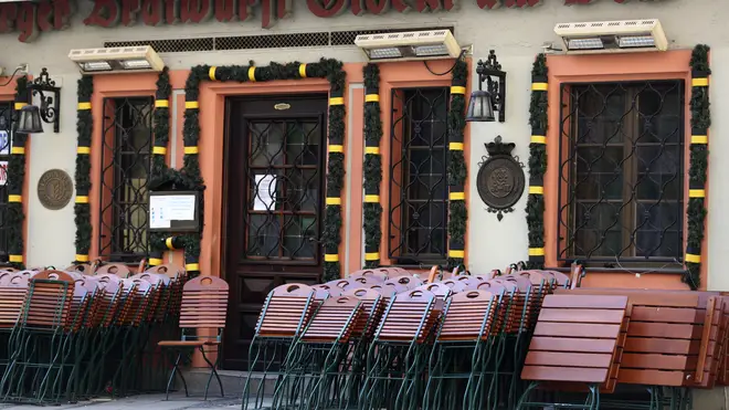Chairs and tables outside a traditional Bavarian restaurant are locked at the city centre in Munich, Germany (Matthias Schrader/AP)