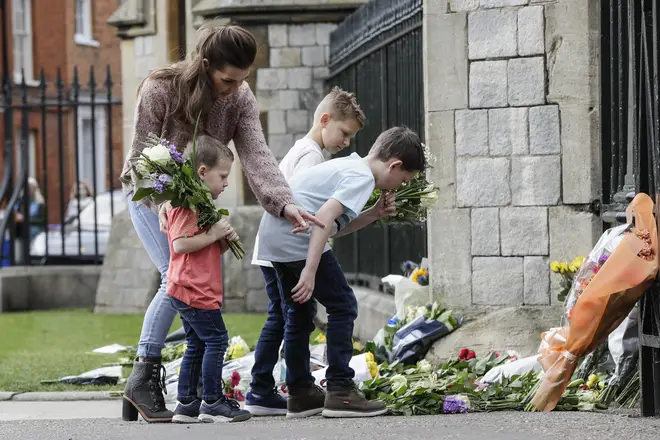 A family lay flowers at Windsor Castle