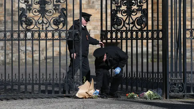 Floral tributes are left at the gates of the Palace of Holyroodhouse, Edinburgh