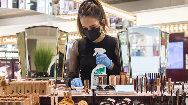 A department store worker cleans products. All non-essential retail can reopen today