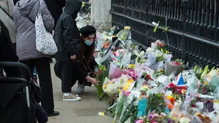 Members of the public lay flowers at Buckingham Palace