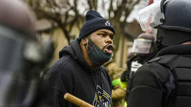 A protester confronts police