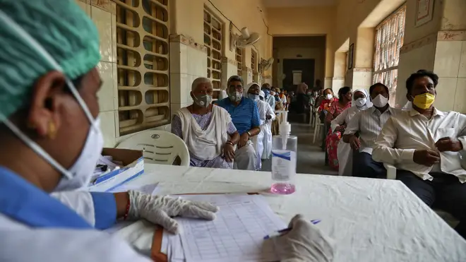 People wait for their turn to be administered Covishield vaccine at a government hospital in Hyderabad, India