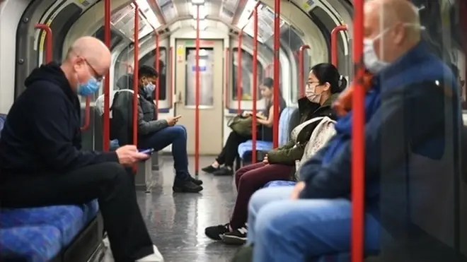 Passengers wear face masks on the tube