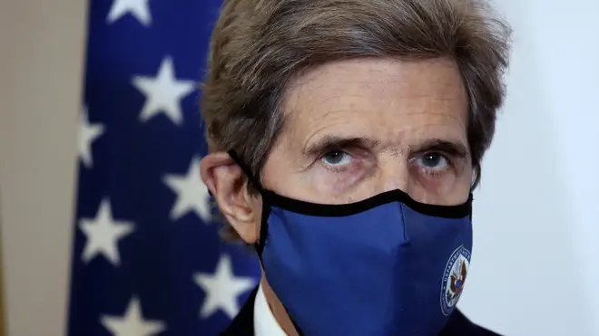 US climate envoy John Kerry wears a blue mask over his nose and mouth