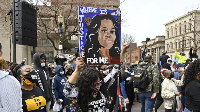 A protester holds up a painting of Breonna Taylor during a rally on the one year anniversary of her death at Jefferson Square Park in Louisville
