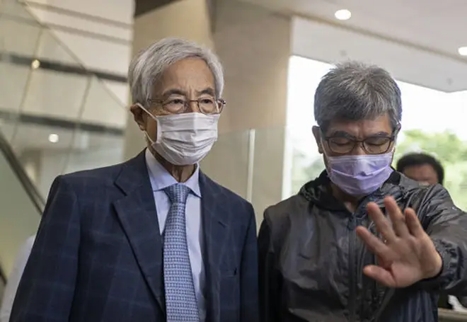 Pro-democracy activist Martin Lee, left, walks out from a court after receiving a suspended sentence