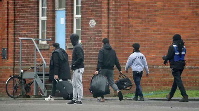 Two men leave Napier Barracks in Folkestone, Kent, which is currently being used by the government to house people seeking asylum in the UK