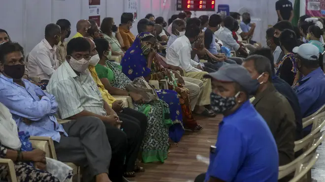 People wait to receive a vaccine in Mumbai, India