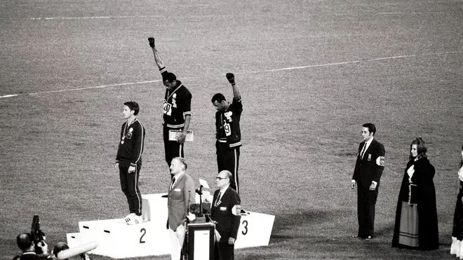 American gold and bronze medallists Tommie Smith (centre) and John Carlos (right) raise their arms as a 'Black Power' gesture during the 1968 Olympics