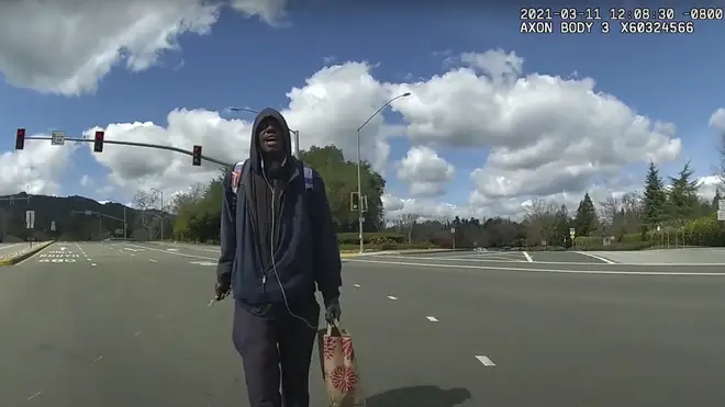 This image from body-worn camera video provided by the Contra Costa Sheriff shows Tyrell Wilson, holding a knife in his right hand, approaching Deputy Andrew Hall in the middle of an intersection on March 11 2021 in Danville, California