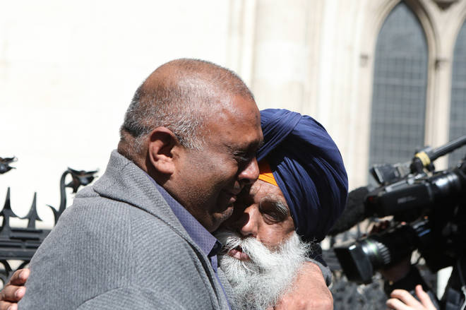 Former post office worker Harjinder Butoy (left) hugs his father outside the Royal Courts of Justice, London, after having his conviction overturned by the Court of Appeal.