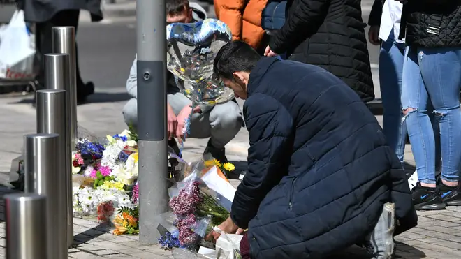 People place flowers at the scene in Barking Road, East Ham, where 14-year-old Fares Maatou was knifed to death