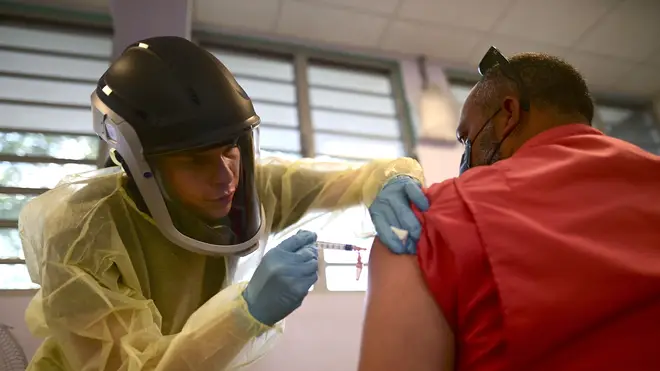 A healthcare worker injects a man with a dose of the Moderna Covid-19 vaccine in Puerto Rico