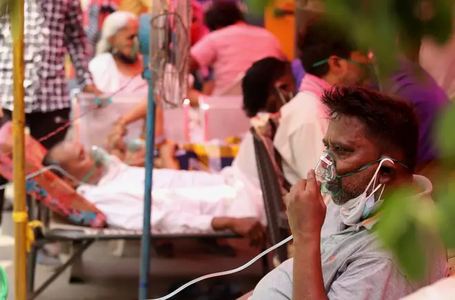 Covid-19 patients suffering from breathing difficulty breath with the help of oxygen masks outside Gurudwara