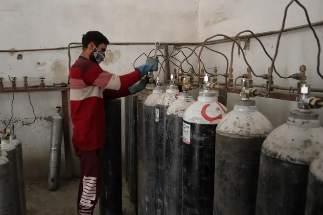 A worker refills oxygen cylinders at a facility as demands rise in the hopitals in Srinagar