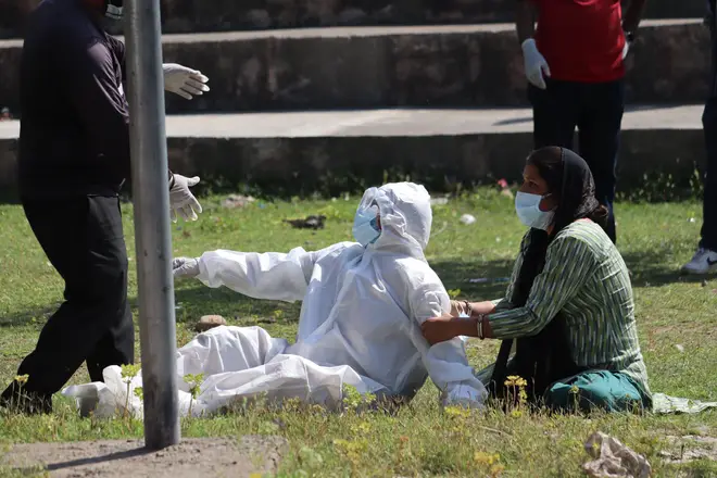 A relative of a woman who died of Covid-19 breaks down during cremation in Poonch