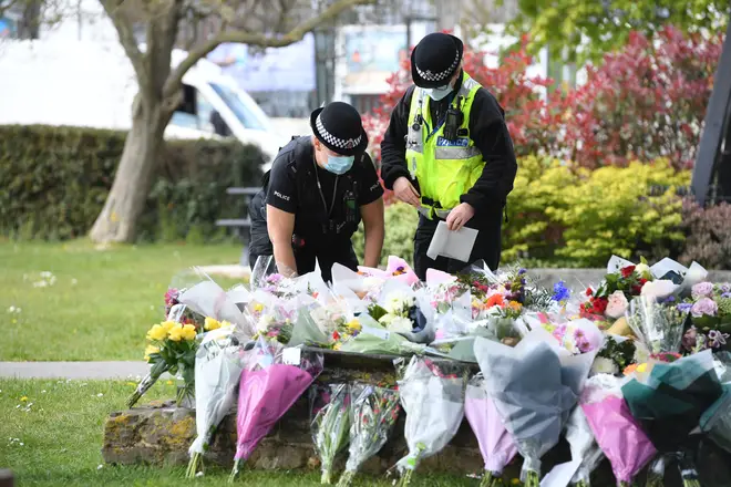 Two police officers lay floral tributes in a park in Aylesham village close to where Ms James was found