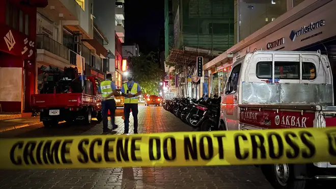 Maldivian police officers stand behind police tape