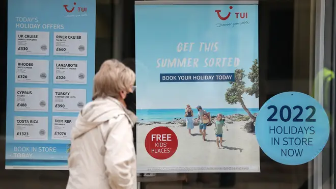 A person makes their way past the shop window of a Tui store in Hampshire