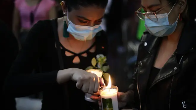 A woman lights a candle during a march demanding justice for the people who died in Monday’s subway collapse, in Mexico City’s south side