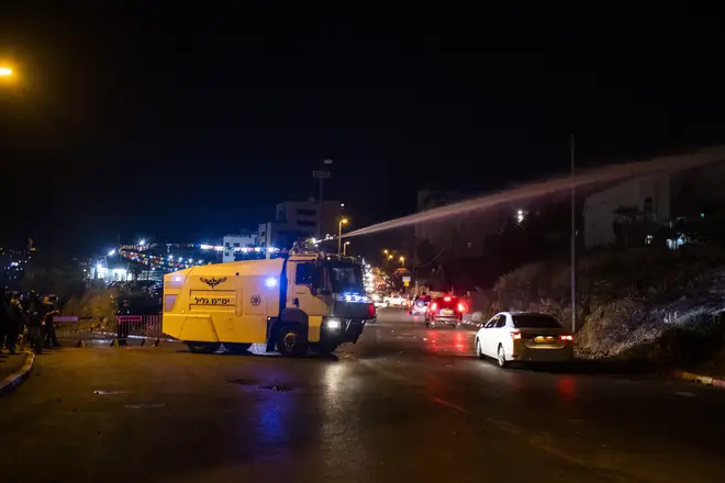 Israeli security forces use a water cannon during a demonstration against the planned eviction in the Sheikh Jarrah neighbourhood.